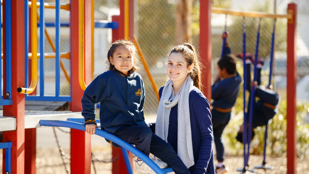 Female teacher with primary student on the playground