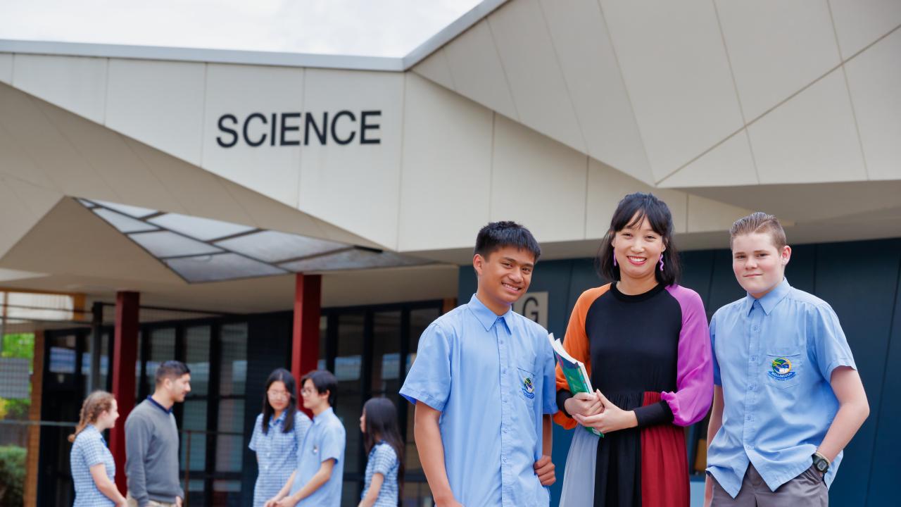 Female teacher with high school students in front of Science building