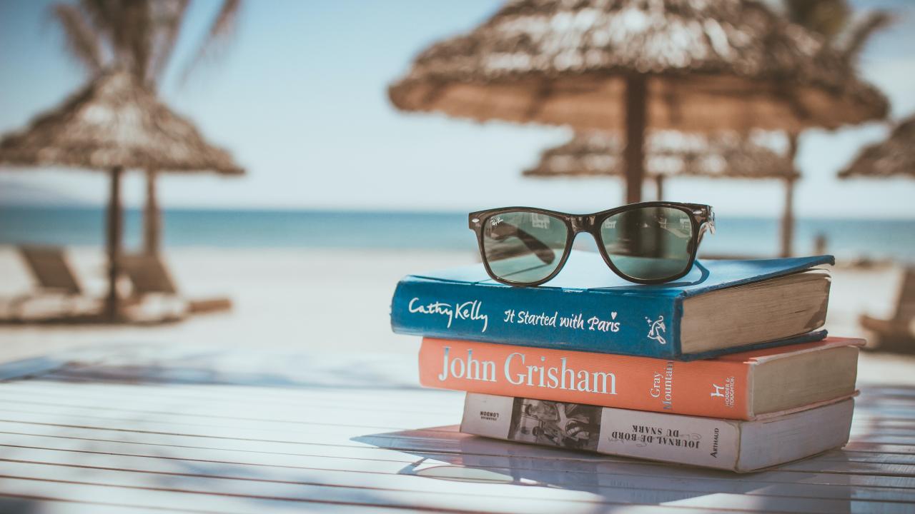 books piled in the foreground on beach